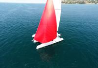 rød spinnaker-gennaker hvid yacht sejler på blå hav